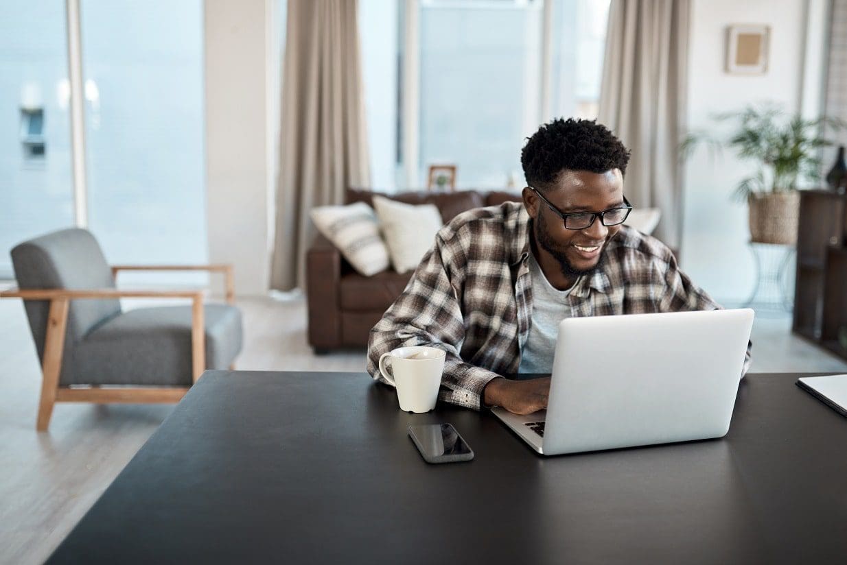 a man sitting at a table with a laptop in front of him